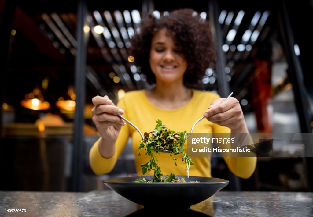 Healthy woman eating a salad at a restaurant