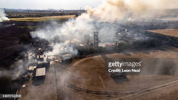 In this aerial view, smoke from fires being fought by fire services seen on July 19, 2022 in Wennington, England. A series of grass fires broke out...