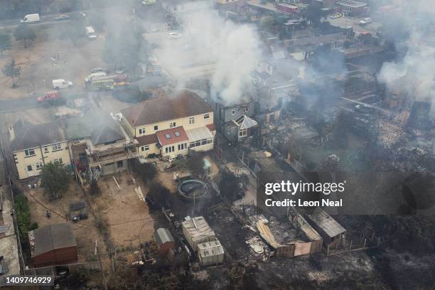 In this aerial view, smoke from fires in a residential area being fought by fire services are seen on July 19, 2022 in Wennington, England. A series...