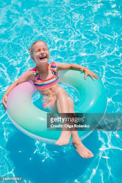 laughing blonde girl go tubing with colorful rubber ring in transparent water - tube girl bildbanksfoton och bilder