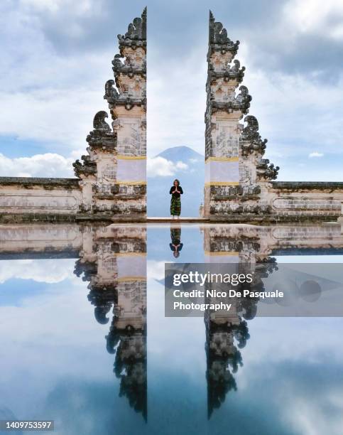 man praying at lempuyang temple gate, bali, indonesia - vendeur stockfoto's en -beelden