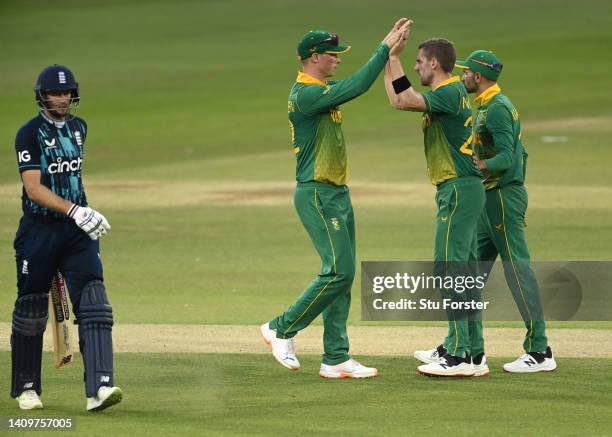 Anrich Nortje of South Africa is congratulated by Rassie van der Dussen of South Africa and Keshav Maharaj of South Africa after bowling out Joe Root...