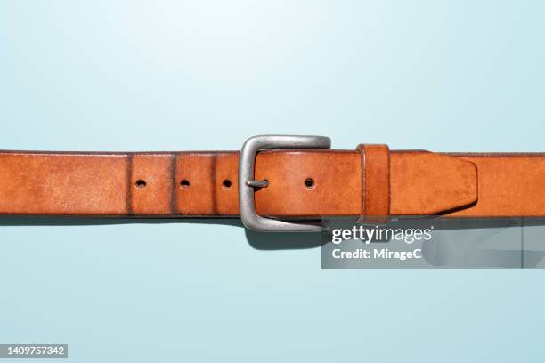 creases on belt indicate a fatter waistline, obesity concept - leather belt fotografías e imágenes de stock