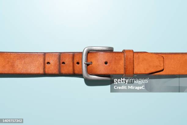 creases on belt indicate a fatter waistline, obesity concept - ceinture par dessus photos et images de collection