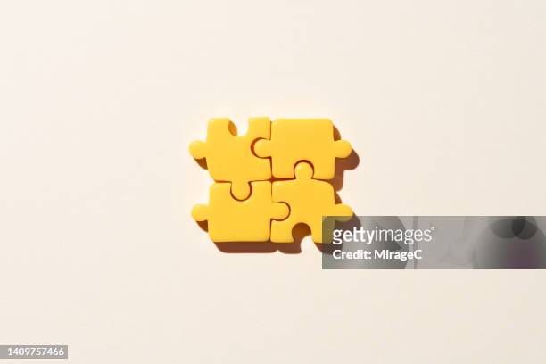 yellow jigsaw puzzle parts on beige background - fond beige photos et images de collection