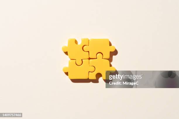 yellow jigsaw puzzle parts on beige background - group c foto e immagini stock