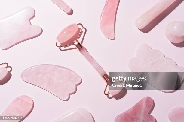 pink crystal gua sha tools collection with face roller flat lay on pink - spooning stock pictures, royalty-free photos & images