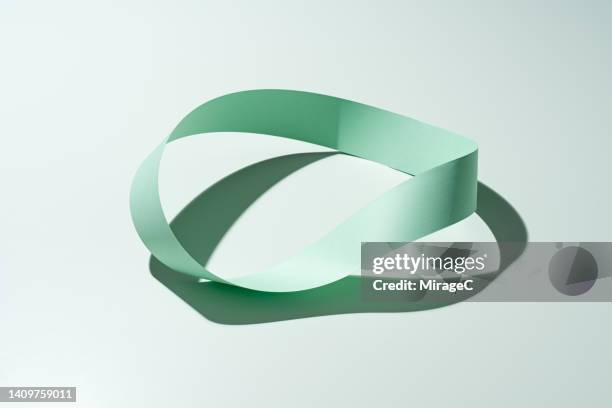 mobius strip made of green paper strip - circular economy stock pictures, royalty-free photos & images