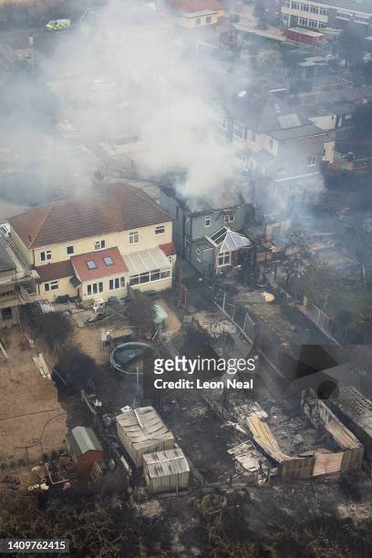 Smoke rising from fires being fought by fire services in a residential area is seen on July 19, 2022 in Wennington, England. A series of grass fires...