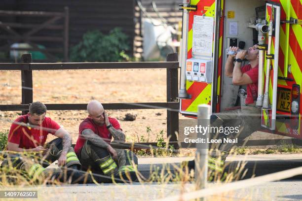 Members of the fire services rest after tackling a huge blaze in a residential area on July 19, 2022 in Wennington, England. A series of grass fires...