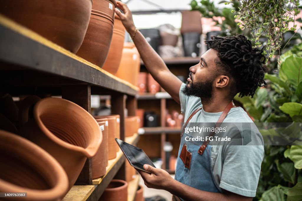 Young salesman working on a digital tablet at a garden center