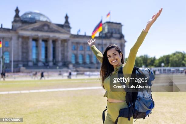 excited woman traveler posing outside the reichstag building in berlin - indian politics and governance stock pictures, royalty-free photos & images