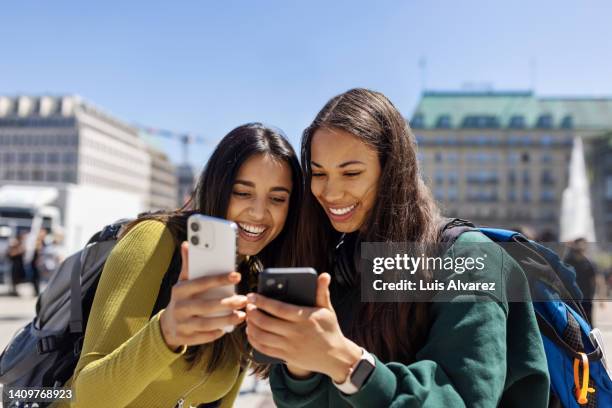 women travelers looking at the pictures on their phones - people on their phones stock pictures, royalty-free photos & images