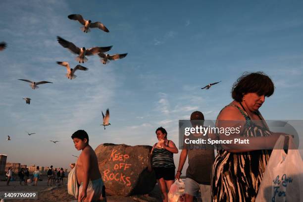 People enjoy a warm evening at Rockaway Beach on July 19, 2022 in New York City. Temperatures in New York City, and much of the East Coast, will rise...