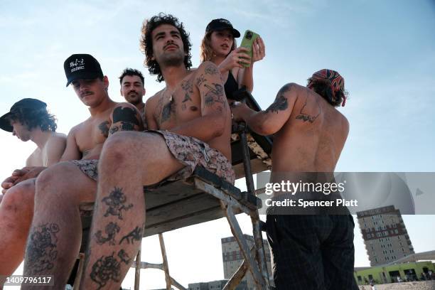 People enjoy a warm evening at Rockaway Beach on July 19, 2022 in New York City. Temperatures in New York City, and much of the East Coast, will rise...