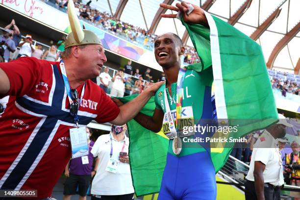 Fan of Team Norway interacts with Alison dos Santos of Team Brazil as he celebrates winning gold in the Men's 400m Hurdles Final on day five of the...