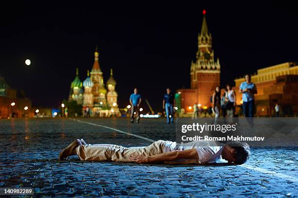 Young man is playing Planking, or Lying Down Game, on the Red Square. Moscow, Russia.