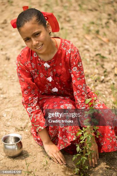 teenage girl planting a plant on rural field - world earth day in india stock pictures, royalty-free photos & images