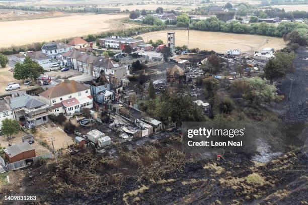 An aerial view shows the rubble and destruction in a residential area following a large blaze the previous day, on July 20, 2022 in Wennington,...