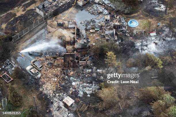 An aerial view shows the rubble and destruction in a residential area following a large blaze the previous day, on July 20, 2022 in Wennington,...