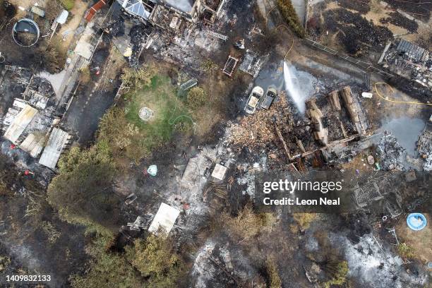 An aerial view shows the rubble and destruction in a residential area following a large blaze the previous day, on July 20, 2022 in Wennington,...