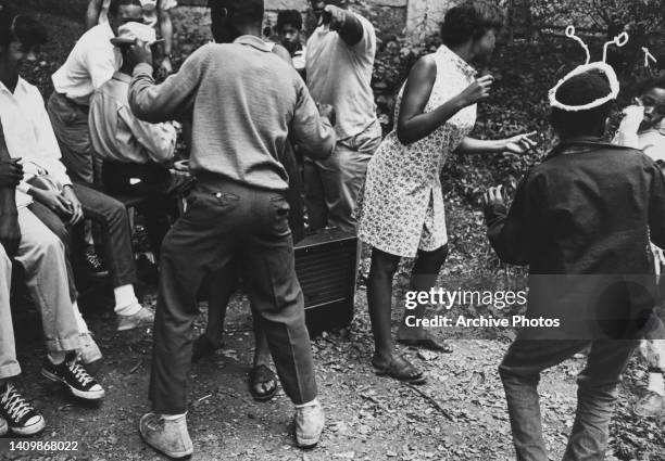 Teenagers dancing around a speaker, US, circa 1970.