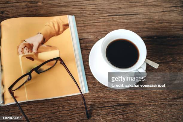 close-up of americano coffee and magazine on the wooden table - media breakfast stock pictures, royalty-free photos & images