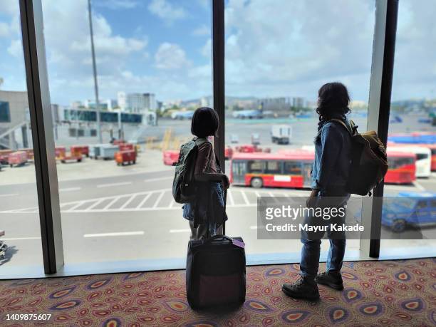 mother and daughter waiting at the airport terminal - indian arrival stock pictures, royalty-free photos & images