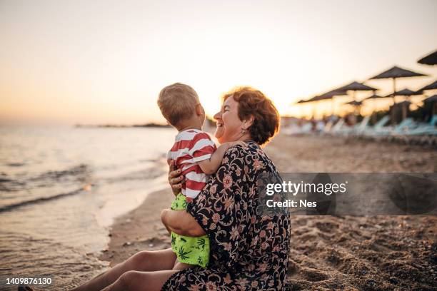 grand-mère et petit-fils sur la plage de sable, vacances d’été - mamie photos et images de collection