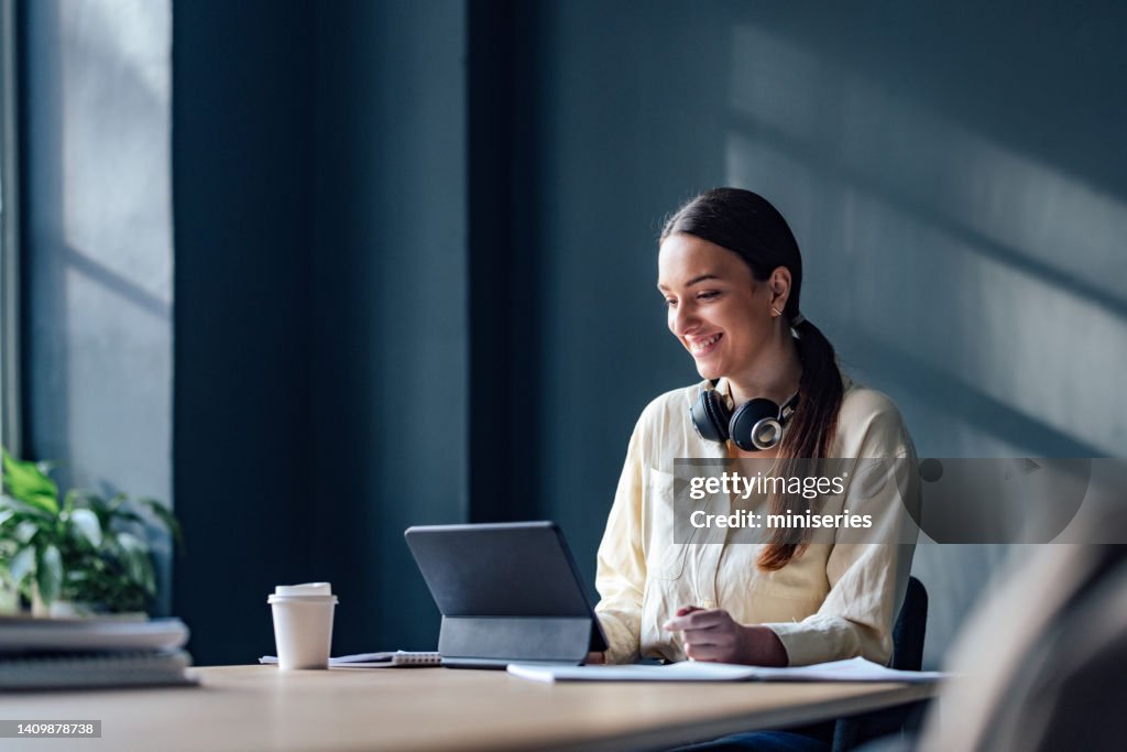 Happy Female Student Studying Online On A Digital Tablet