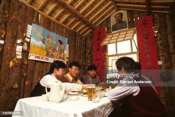 View of patrons as they eat a meal in a private dining room at the restaurant, Heitudi , Beijing, China, April 1994. The restaurant is modelled on...