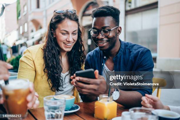 junge freunde beim gemeinsamen kaffeegenuss. - couple smartphone stock-fotos und bilder