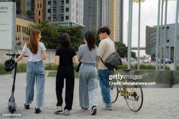 young business team having discussion while walking in office park. - partnership men bikes stockfoto's en -beelden