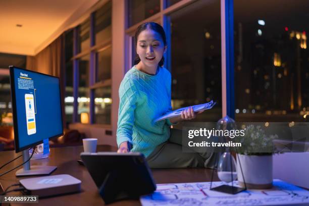 asian female woman works in office in late evening against background of lights of bokeh the night of the city background,young asia businesswoman using apc desktop in home office at night - staring stock pictures, royalty-free photos & images