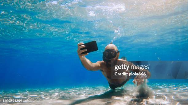 selfie with mobile phone underwater at sea: social media addiction - sea iphone stock pictures, royalty-free photos & images