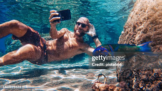 Selfie with mobile phone underwater at sea: fish photobombing Selfie with mobile phone underwater at sea: fish photobombing