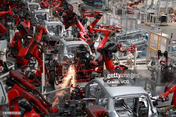 Robotic arms work on the assembly line of T03 electric small crossover at a factory of Chinese EV startup Leapmotor on July 20, 2022 in Jinhua,...