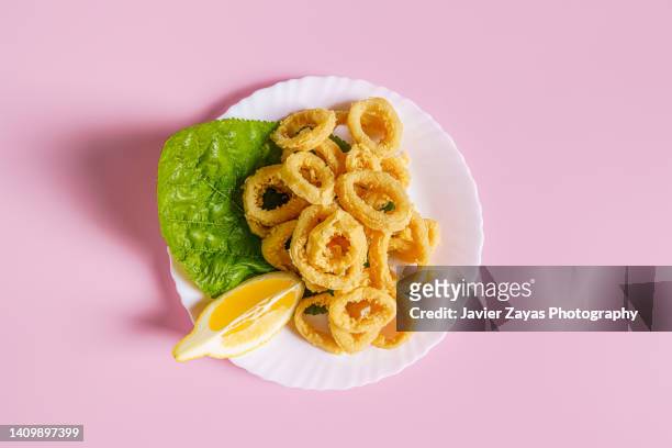 delicious deep-fried calamari rings - frituur stockfoto's en -beelden
