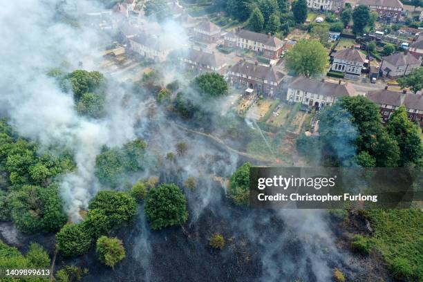 In this aerial view Firefighters contain a wildfire that encroached on nearby homes in the Shiregreen area of Sheffield on July 20, 2022 in...