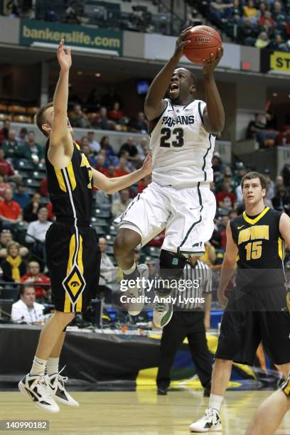 Draymond Green of the Michigan State Spartans drives for a shot attempt in the first half against Josh Oglesby of the Iowa Hawkeyes during their...