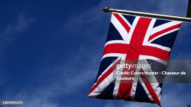 hanging in the air from a flagpole, the flag of the united kingdom against a blue sky in london, england, uk - british and eu flag bildbanksfoton och bilder