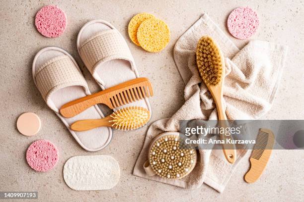 wooden body brushes for dry brushing massage, slippers, cleaning sponges, loofah sponge, hair brushes and bath towel on concrete background, top view. spa at home concept. zero waste. flat lay. - dry brush stock pictures, royalty-free photos & images