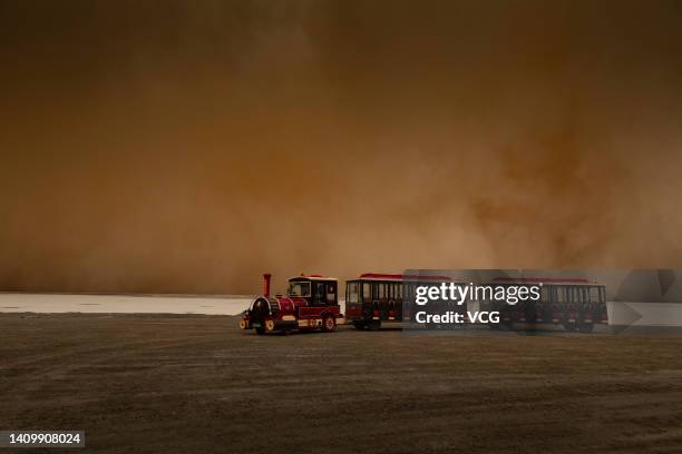 Shuttle vehicle sits parked at the Emerald Lake tourist attraction in Da Qaidam Town during a sandstorm on July 20, 2022 in Da Qaidam District, Haixi...
