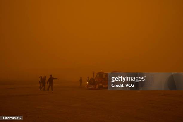 Toursits walk at the Emerald Lake tourist attraction in Da Qaidam Town during a sandstorm on July 20, 2022 in Da Qaidam District, Haixi Mongol and...
