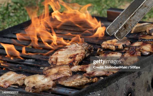overturning meat on barbeque with meat gripper - vom holzkohlengrill stock-fotos und bilder