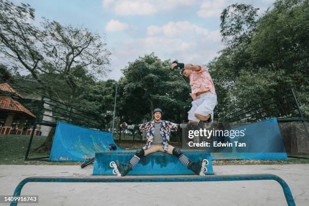 asian chinese gay person enjoying inline skating with his friend practising at skate park during weekend activity - inline skate stock pictures, royalty-free photos & images