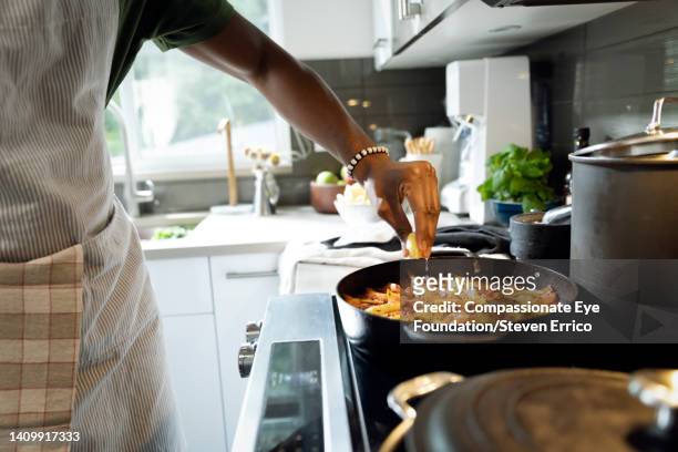close up of man cooking in kitchen - piano del fornello foto e immagini stock