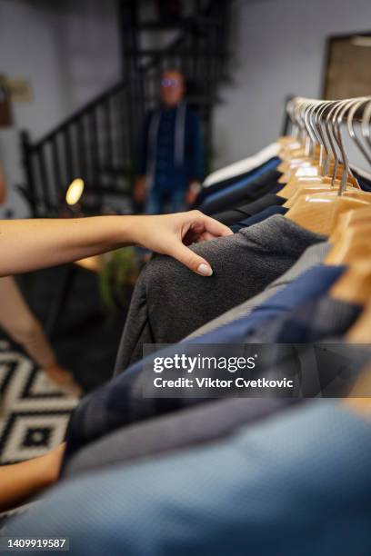 close up photography of female worker trying to find best suit in the store - clothes rack stock pictures, royalty-free photos & images
