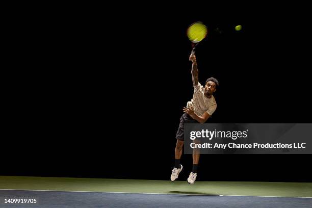 youngtennis player in action serving the ball - aufschlagen sport stock-fotos und bilder