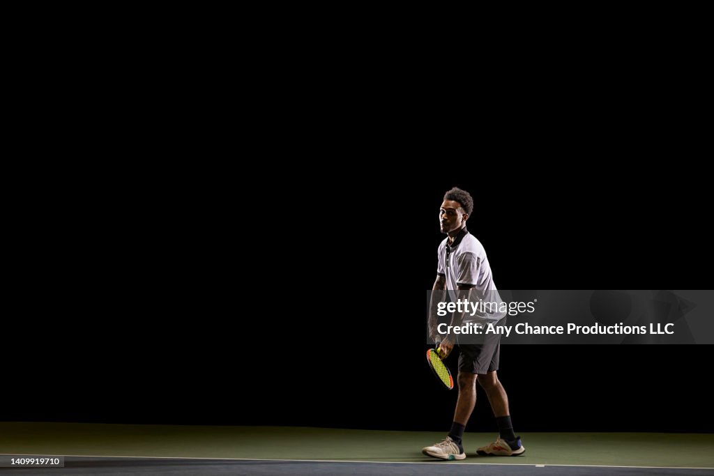 Tennis player preparing to serve during a game